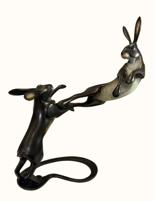 two bronze hares boxing each other