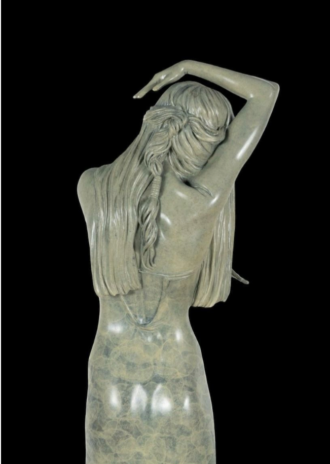 Statue of a woman with long hair against a black background