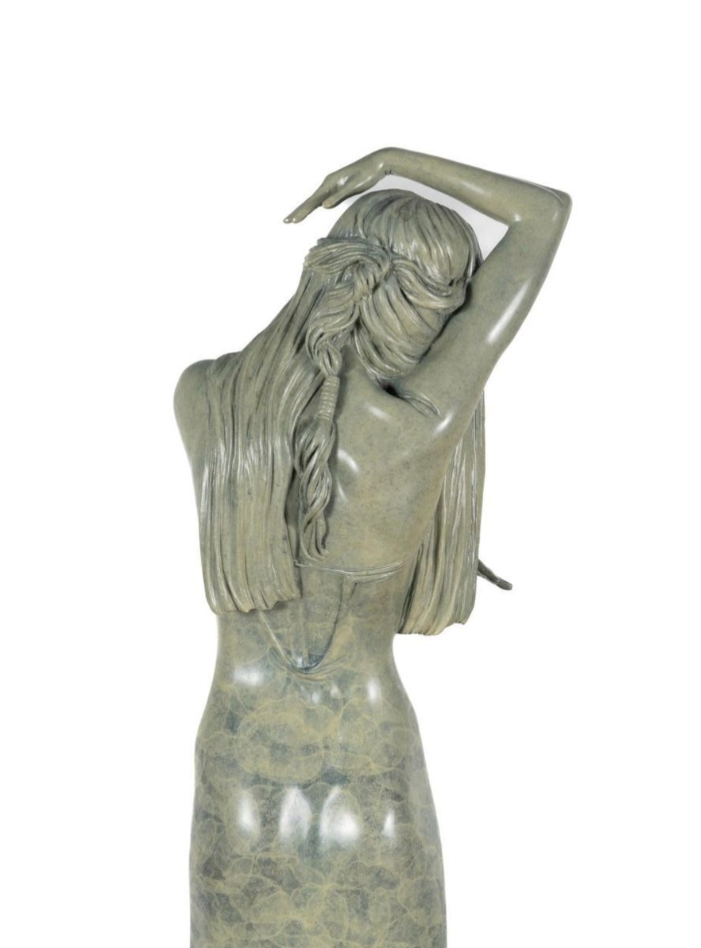 Statue of a woman with long hair against a white background