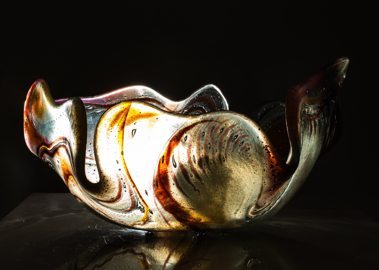 Decorative glass bowl with swirling patterns on a dark background
