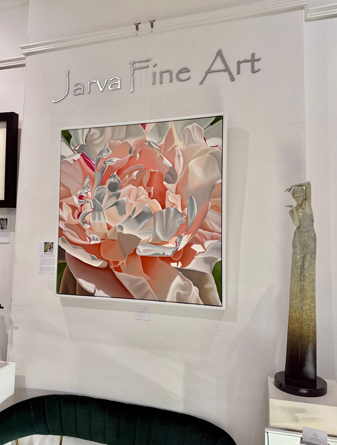 Jarva Fine Art display with a floral painting and sculpture on a white wall.