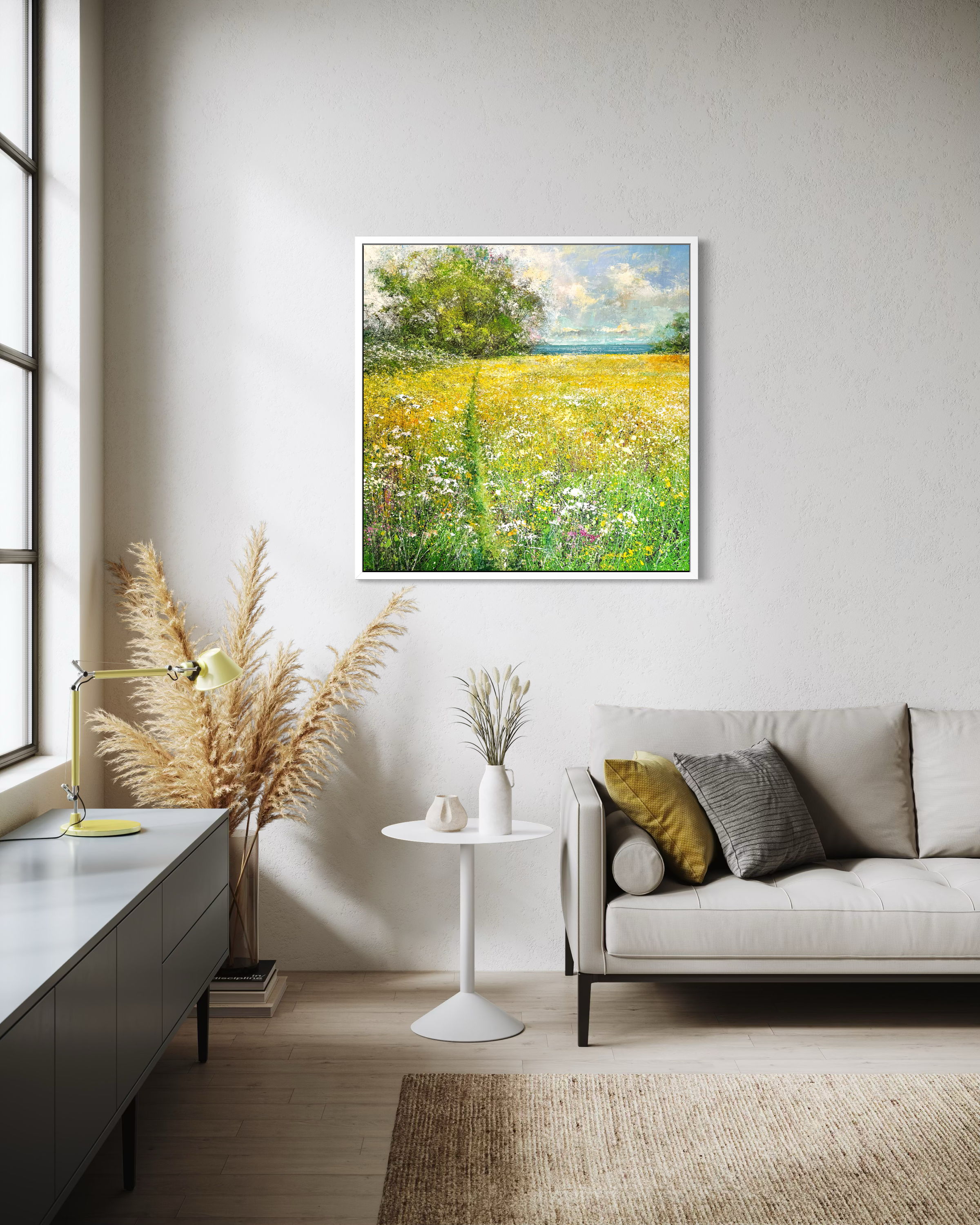 Framed artwork of a contemporary landscape of yellow wildflowers and sea in situ a modern lounge.