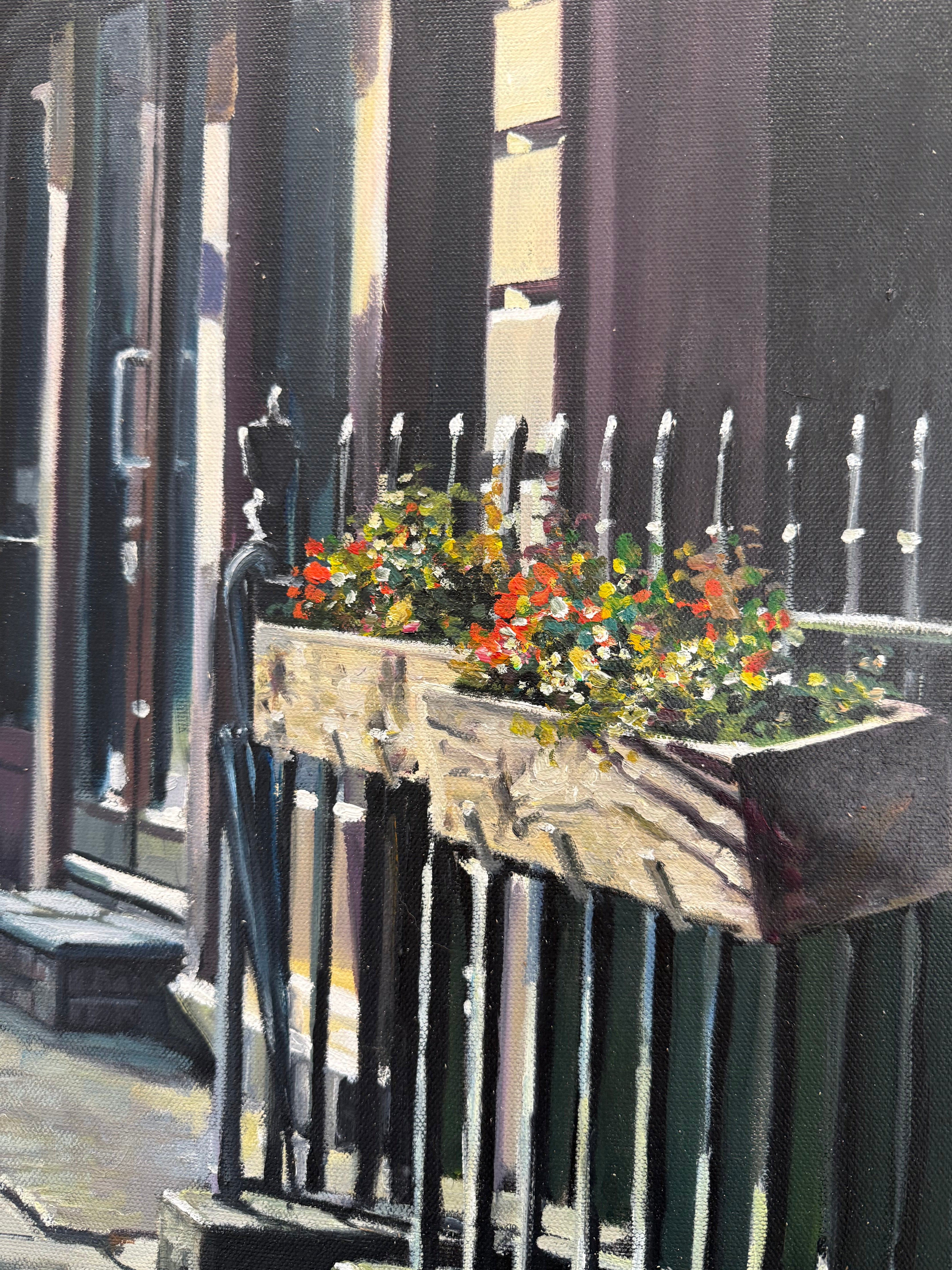 Floral planter in London on black metal railings with an umbrella attached detail image of section of oil painting