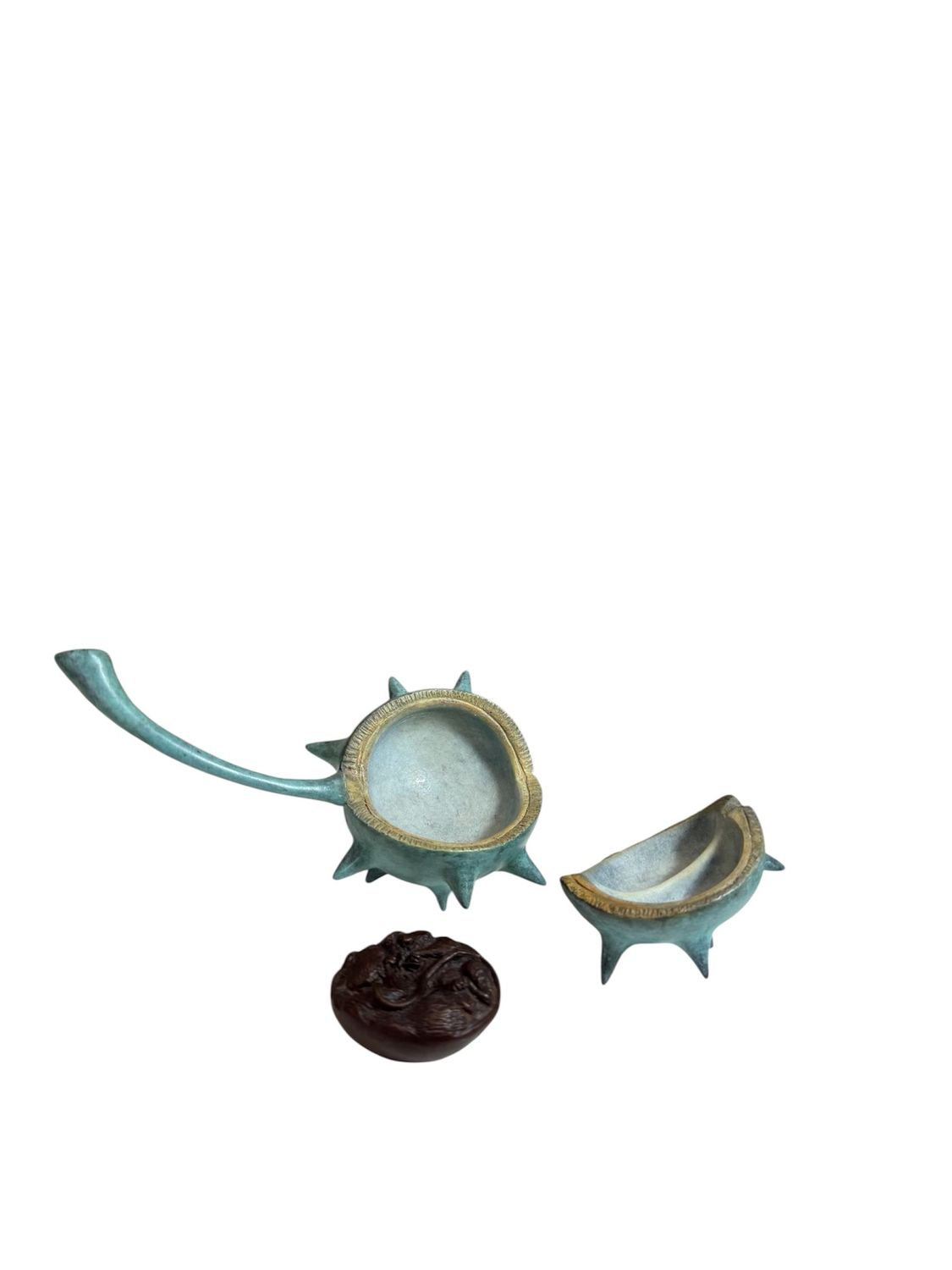 Decorative bronze piece with a long handle and two smaller components on a white background