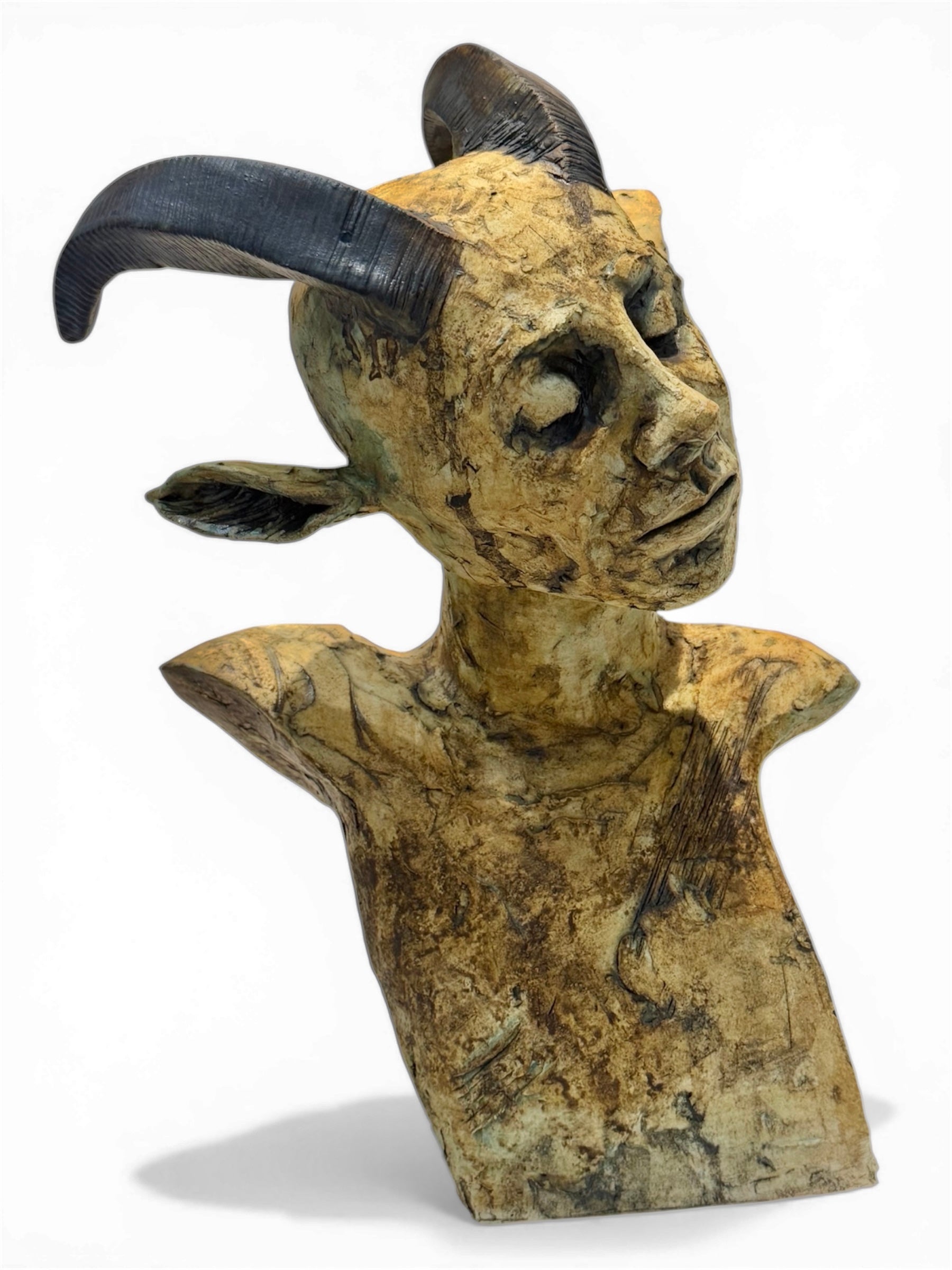 ceramic Bust of a creature with large horns on a white background