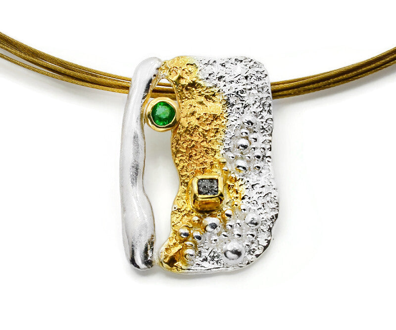 Gold and silver pendant with gemstones on a white background