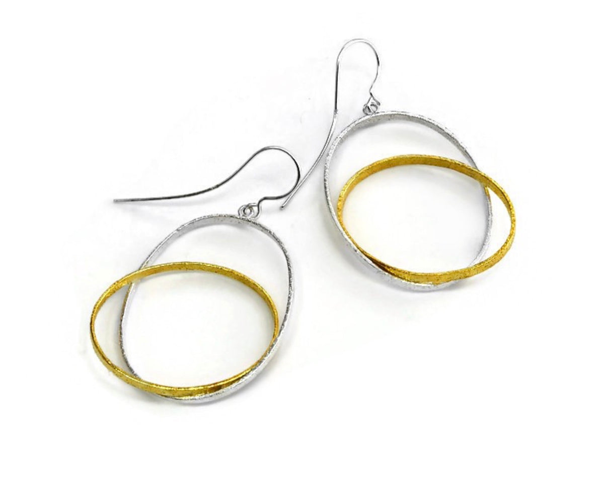 Pair of earrings with gold and silver circular designs on a white background