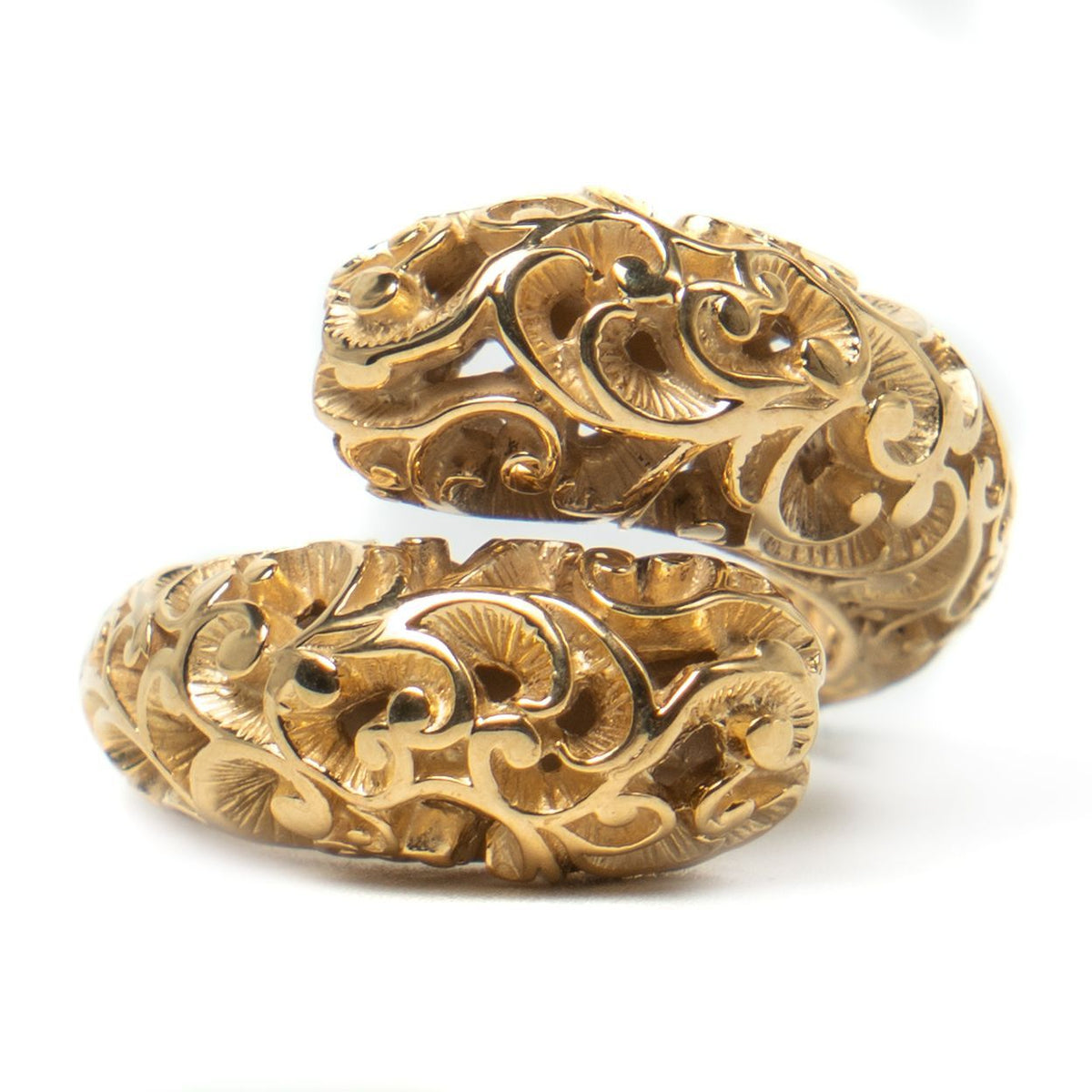 Gold ring with intricate designs on a white background