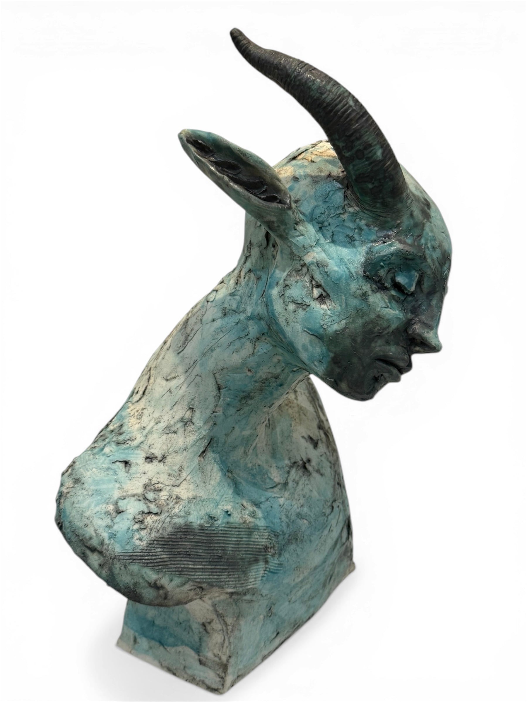 ceramic sculpture of a goat head on a white background