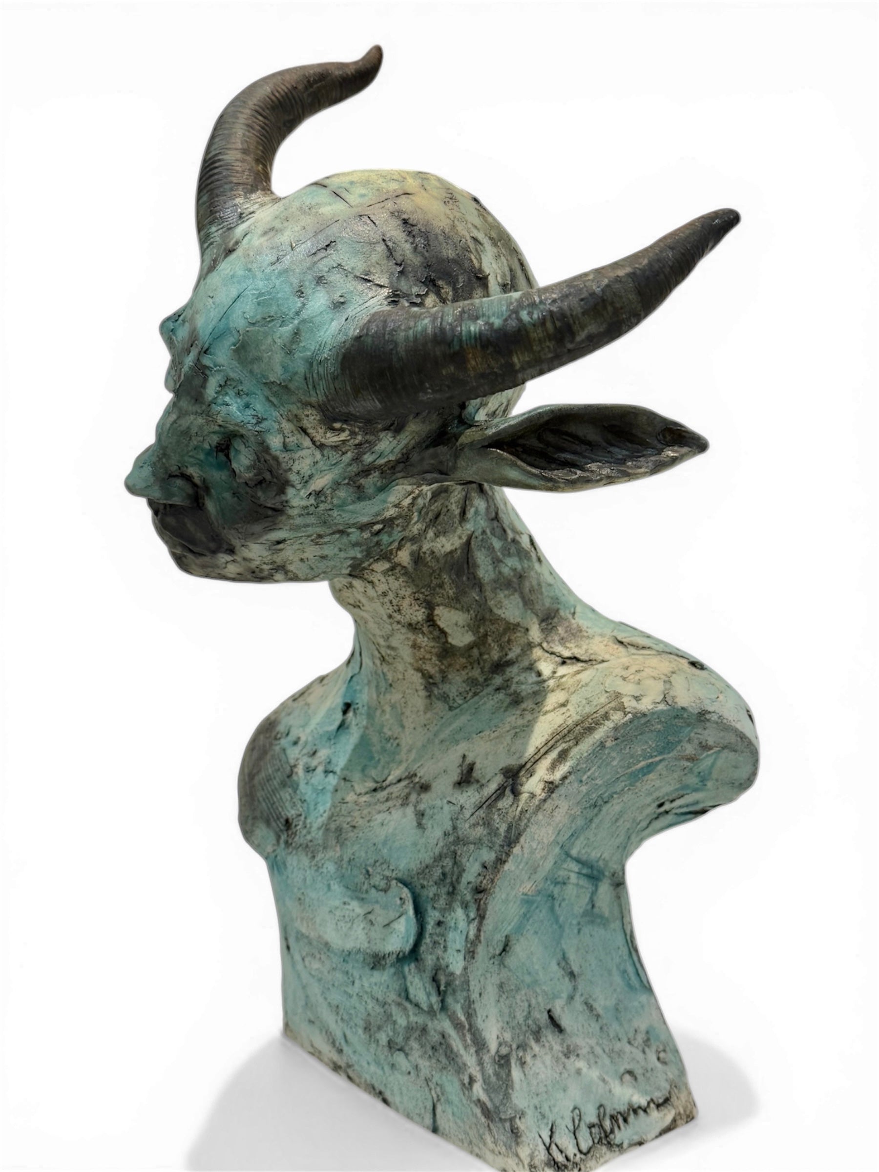 ceramic sculpture of a goat head on a white background