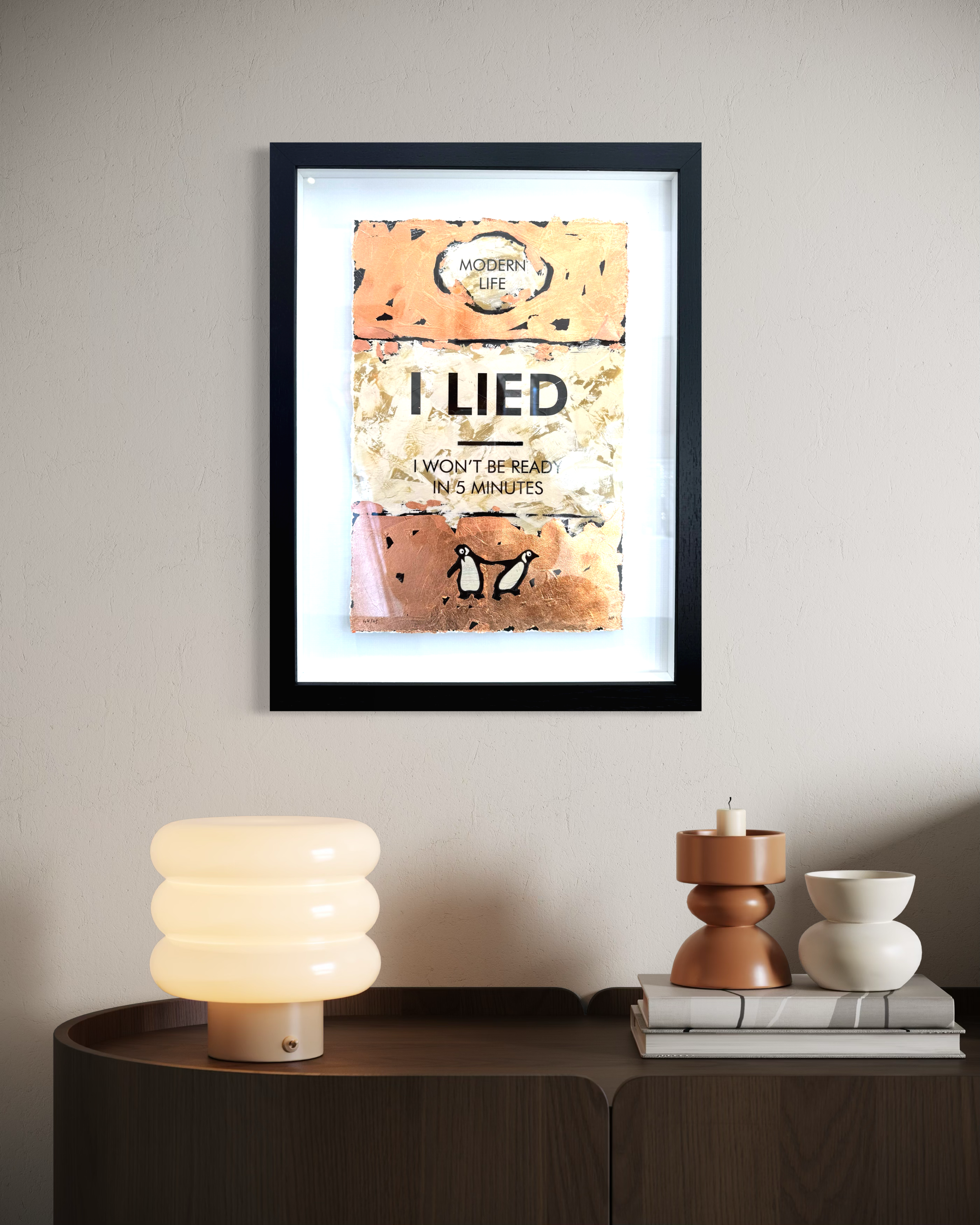 Framed poster on a wall above a side table with decorative items.