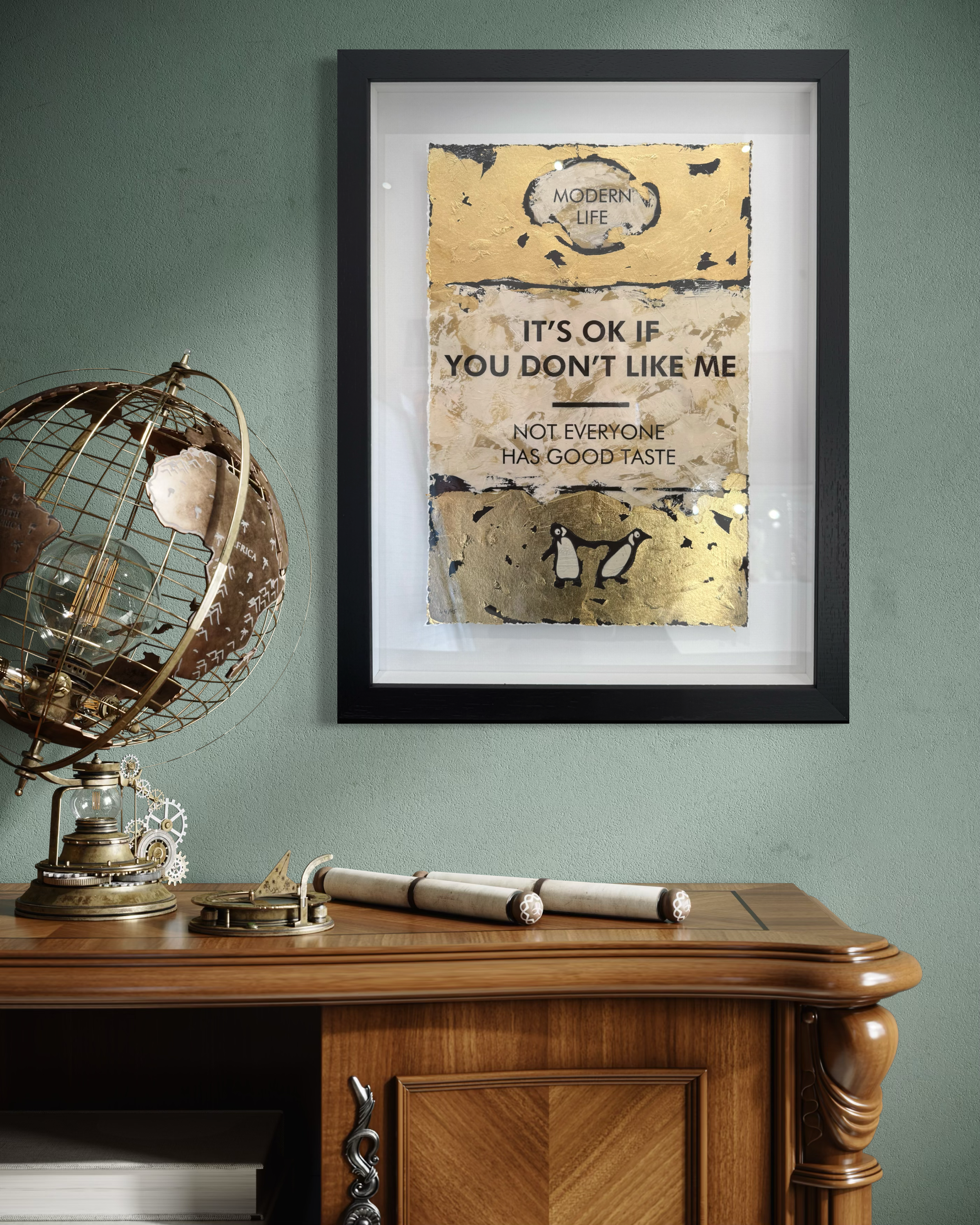 Framed artwork on a wall above a wooden desk with decorative items.