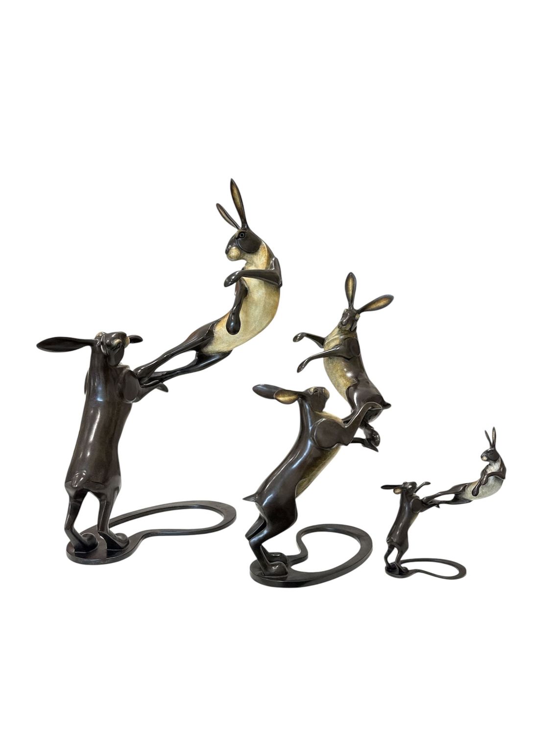 Set of bronze rabbit sculptures on a white background