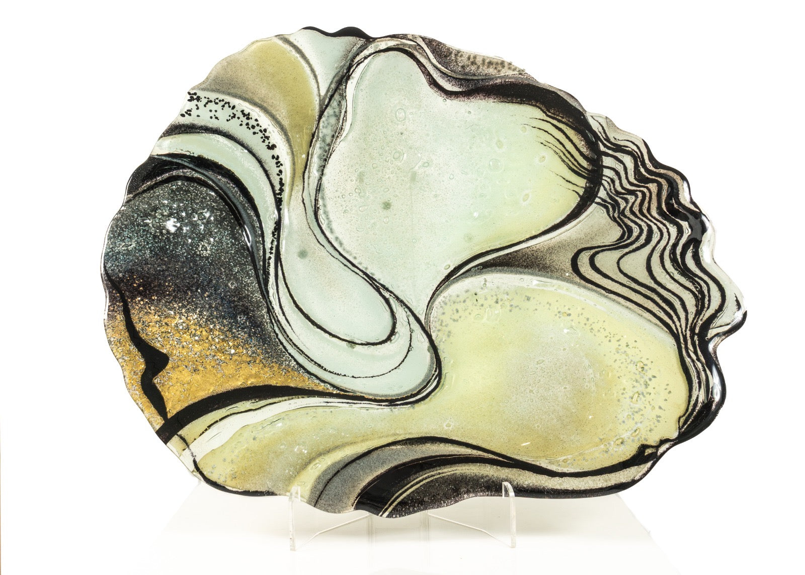 Decorative glass plate with swirling black, white, and gold design on a white background