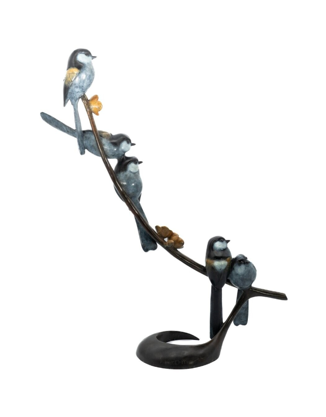 Decorative metal sculpture of birds on a branch with a white background