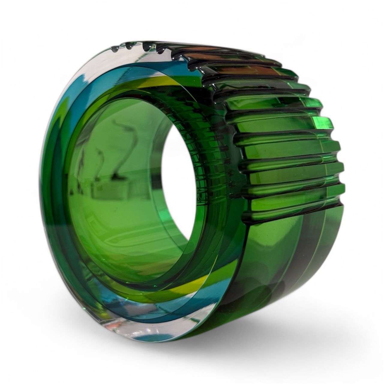 Multicolored ring with green, blue, and clear segments on a white background