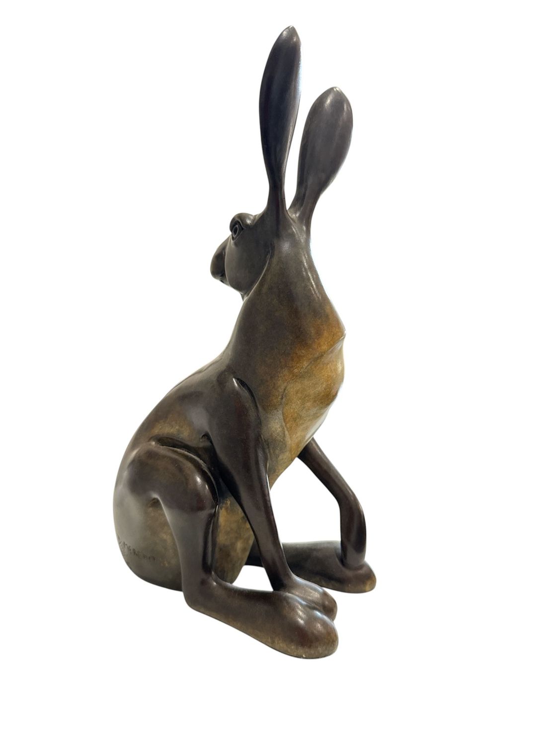 Bronze sculpture of a sitting animal on a white background