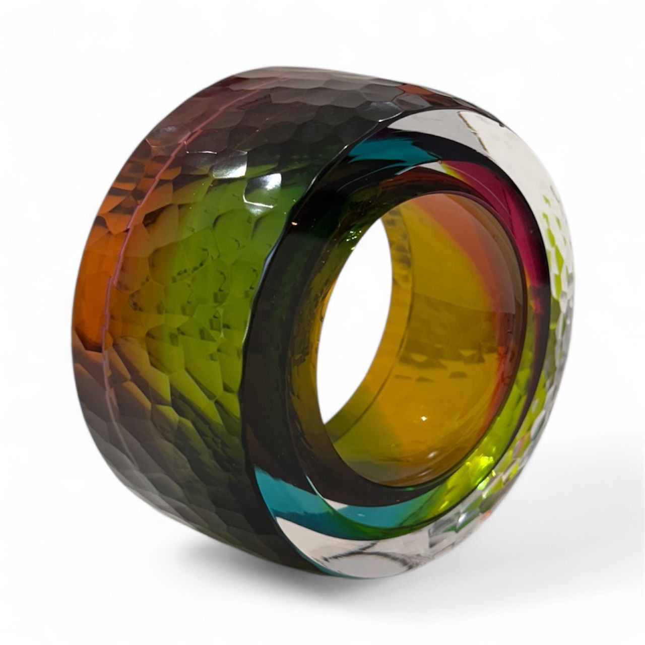 Multicolored glass ring with a textured surface on a white background