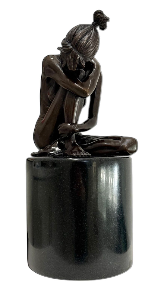 Bronze sculpture of a figure sitting on a black marble cylindrical base