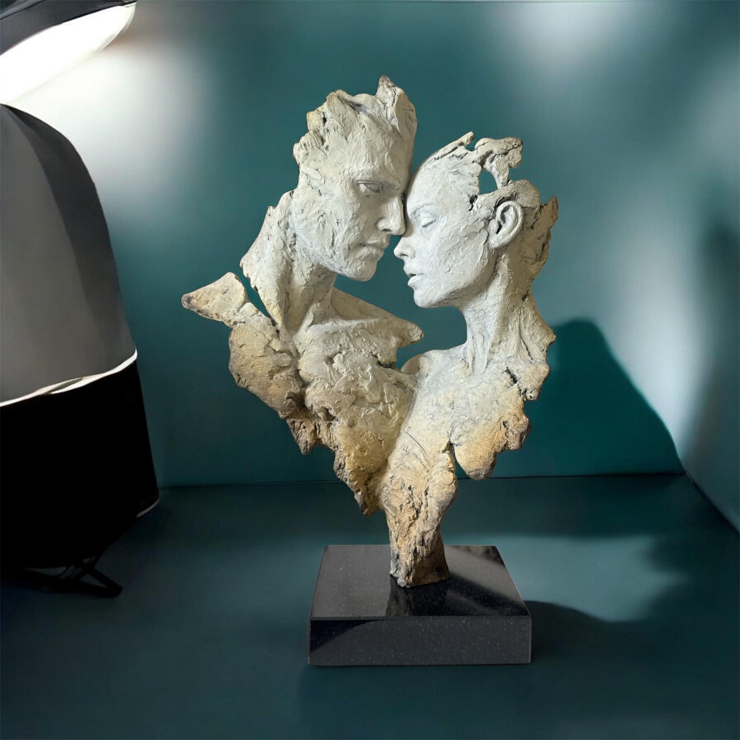 Abstract sculpture of two faces on a stand with a blurred background