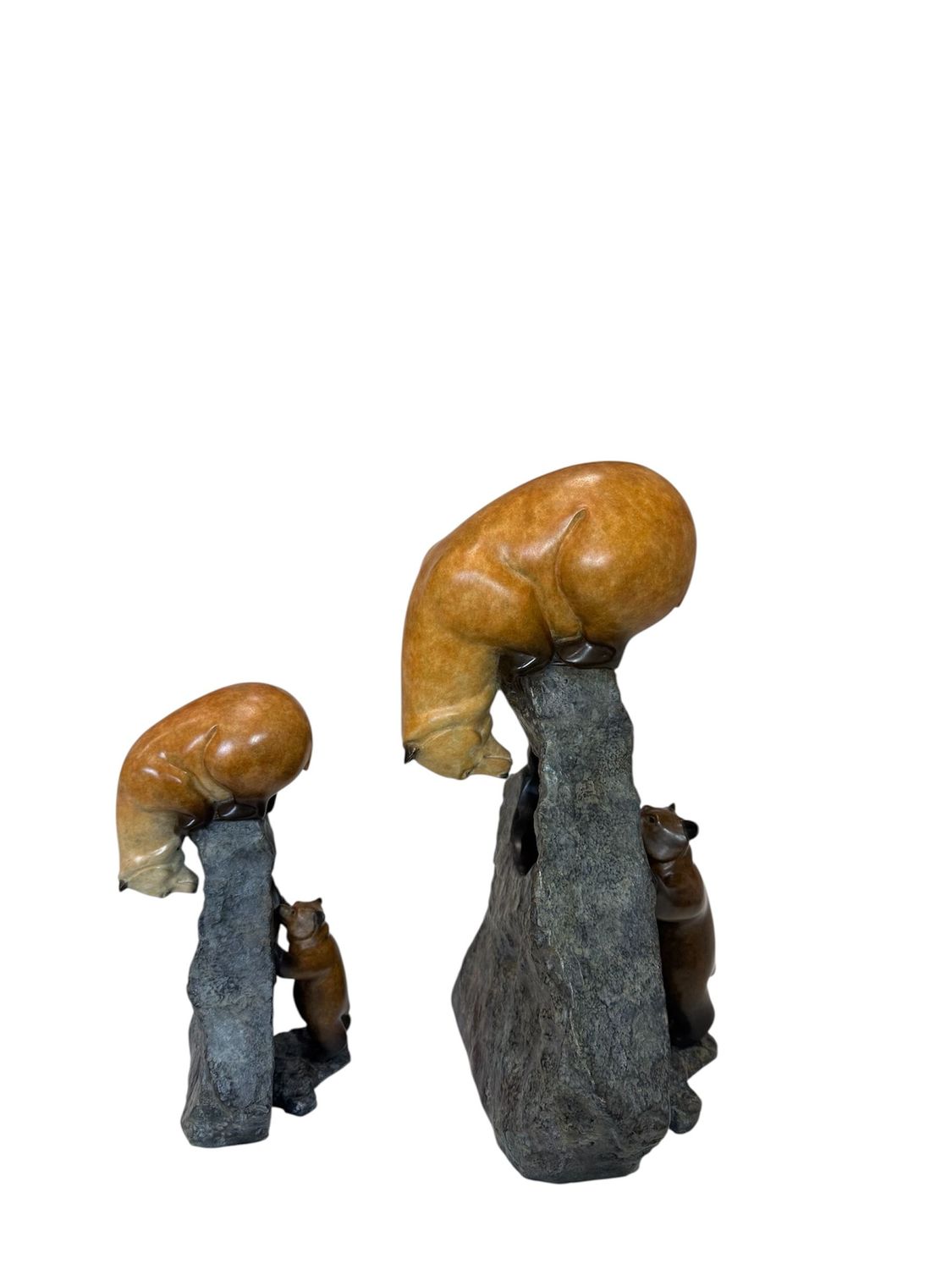 Two stone sculptures of bears with large rock on a white background