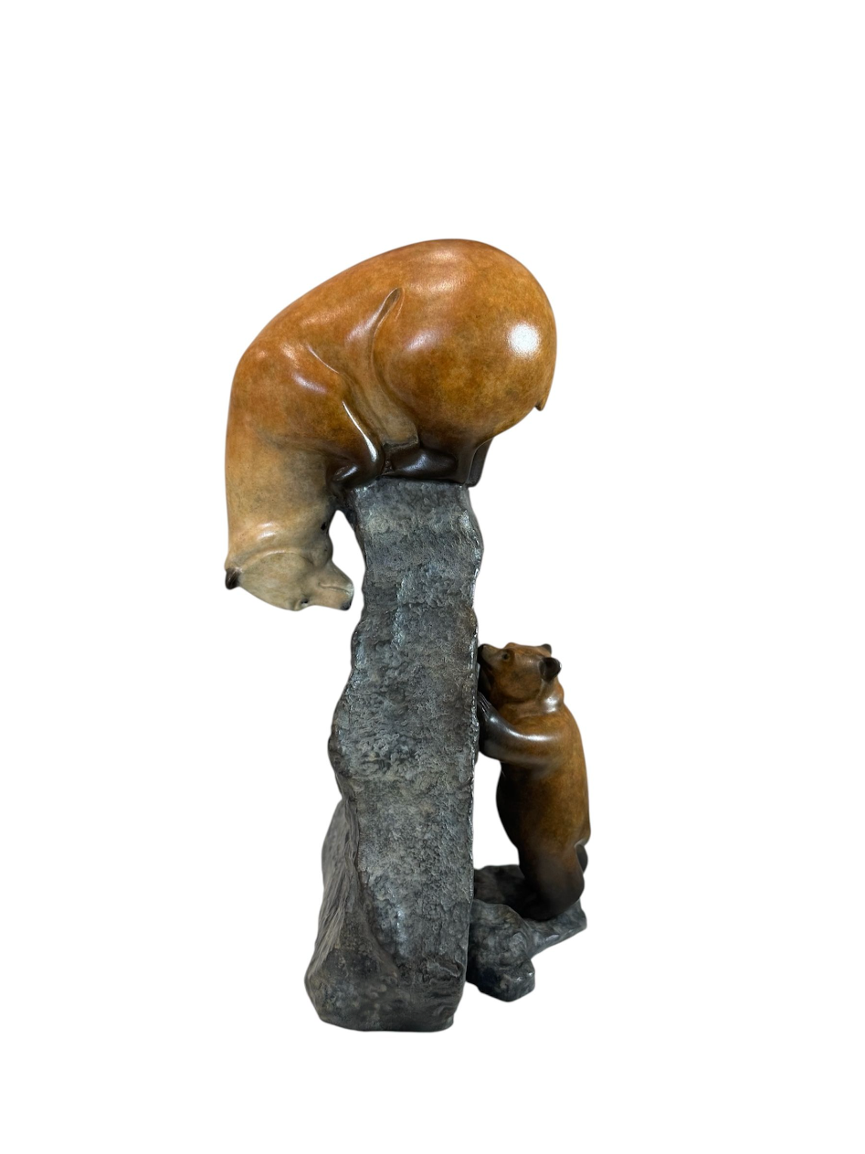 Carved stone sculpture of a bear and cub on a white background