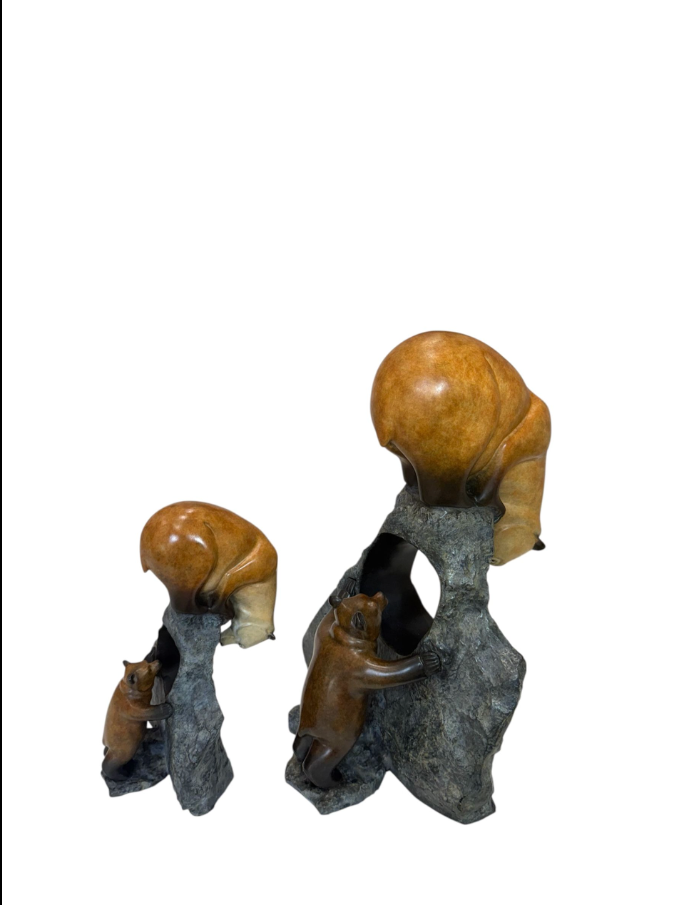 Two bronze sculptures of a mother and baby bear on a white background