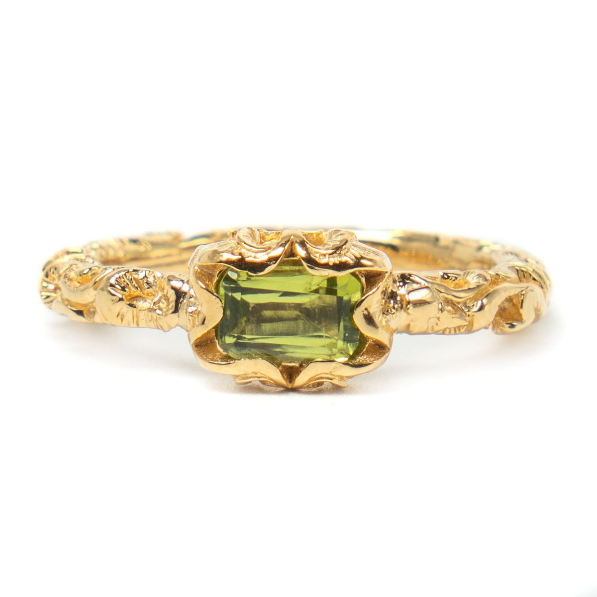 Gold ring with a green gemstone on a white background
