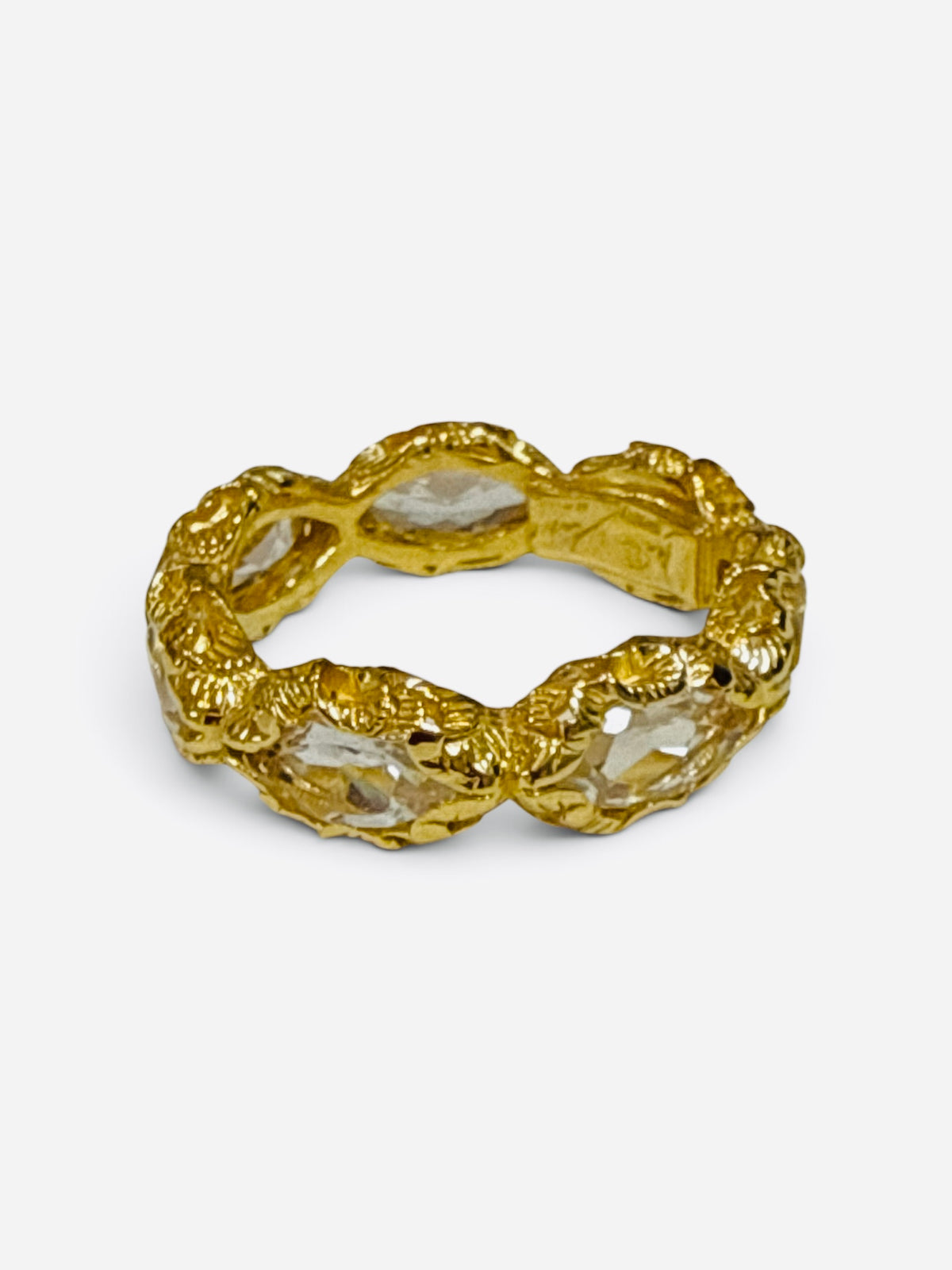 A textured gold ring featuring organic, wavy clear crystal inlays, photographed on a clean light gray background.