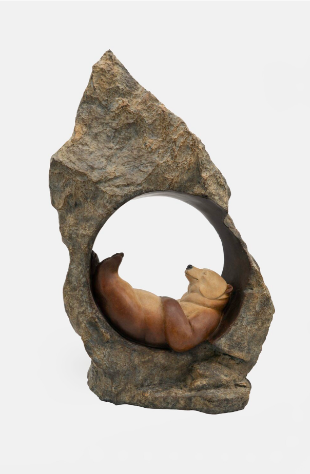Stone sculpture of a bear resting inside a circular opening
