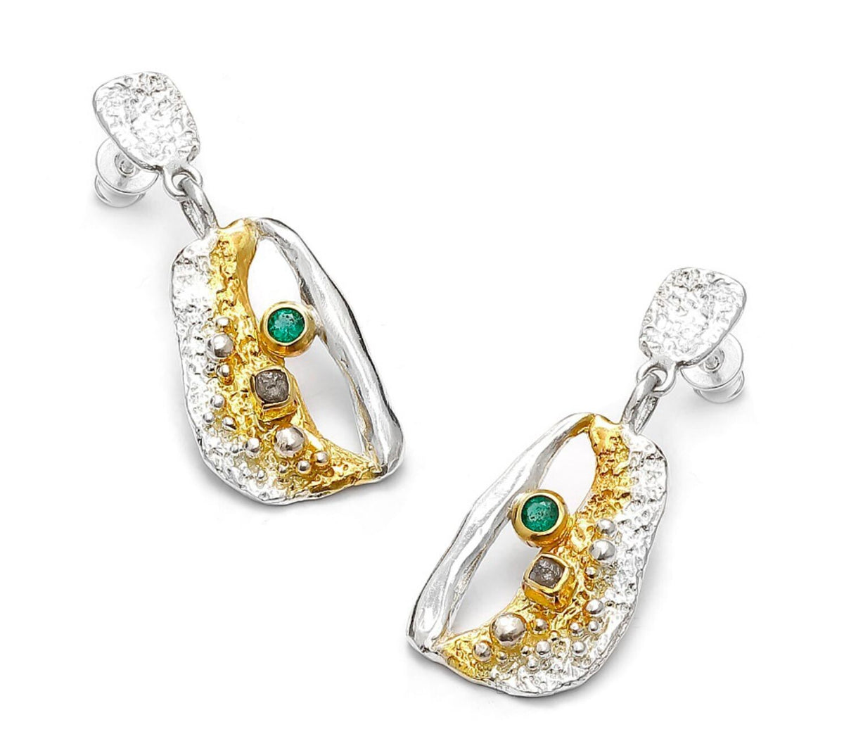Gold and silver earrings with emeralds on a white background