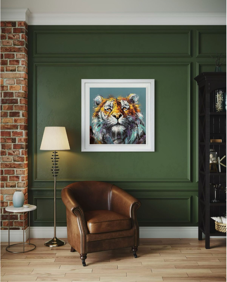 Framed artwork of a tiger on a green wall with a brown leather chair and lamp in the foreground.