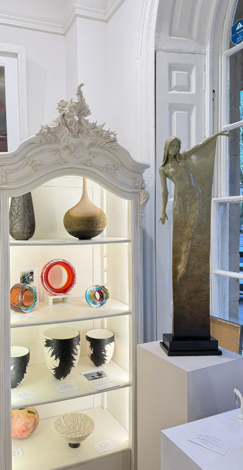 Decorative items including vases and sculptures displayed in a white cabinet.