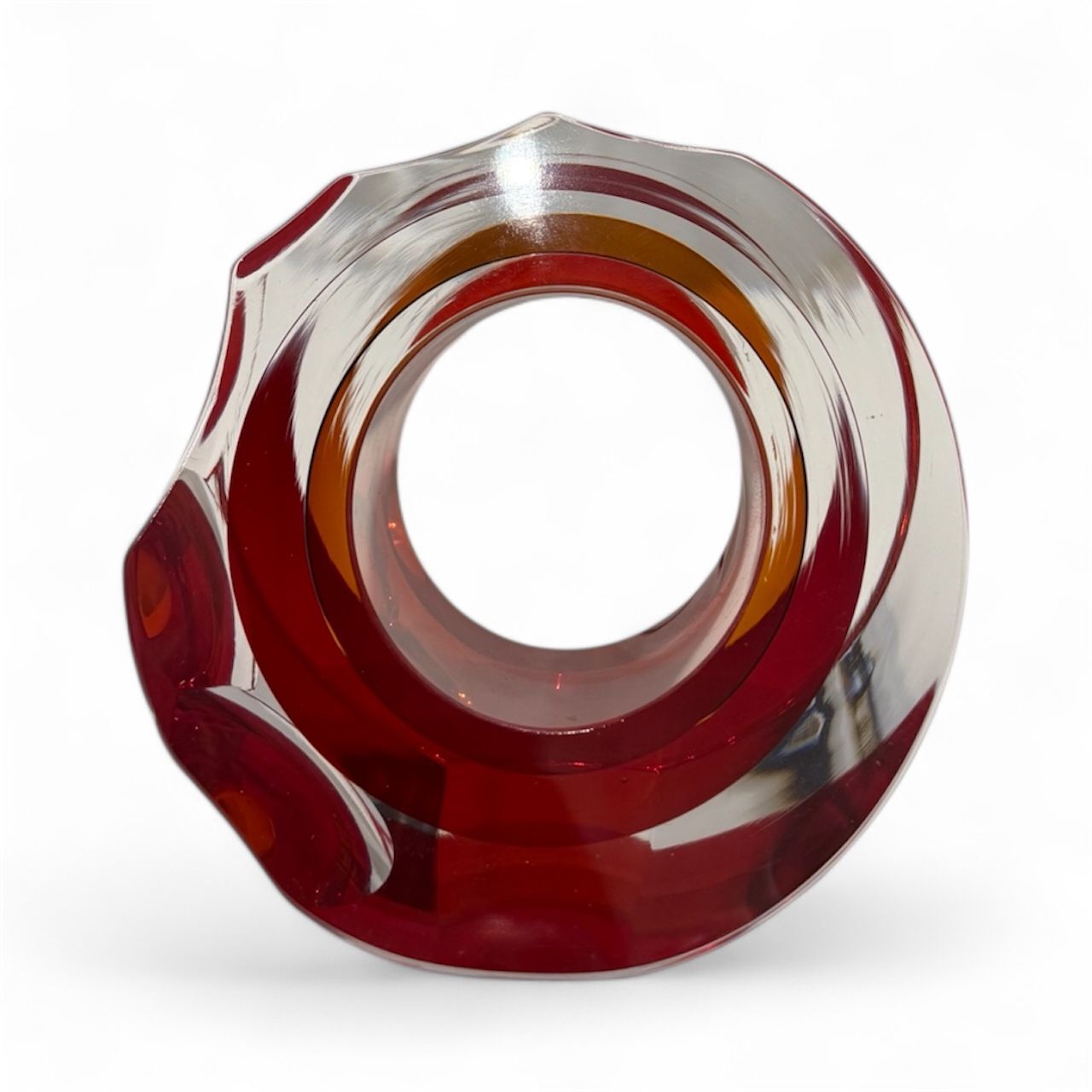 Glass object with red and clear design on a white background