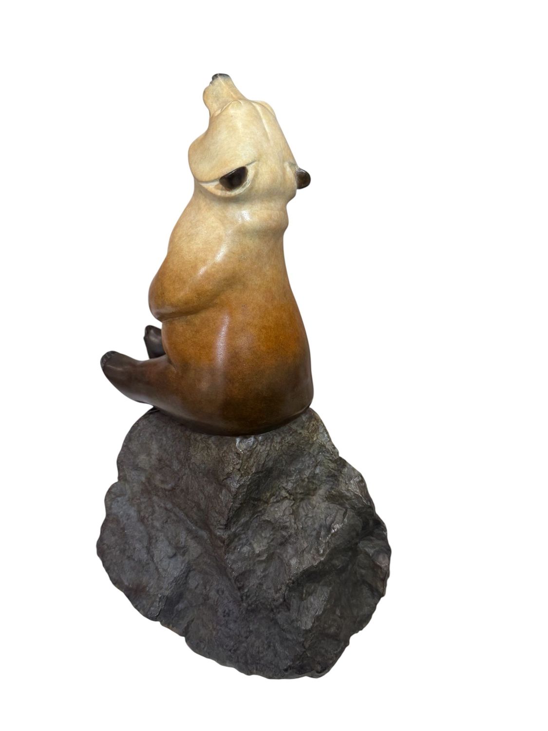Sculpture of a bear on a rock with a white background