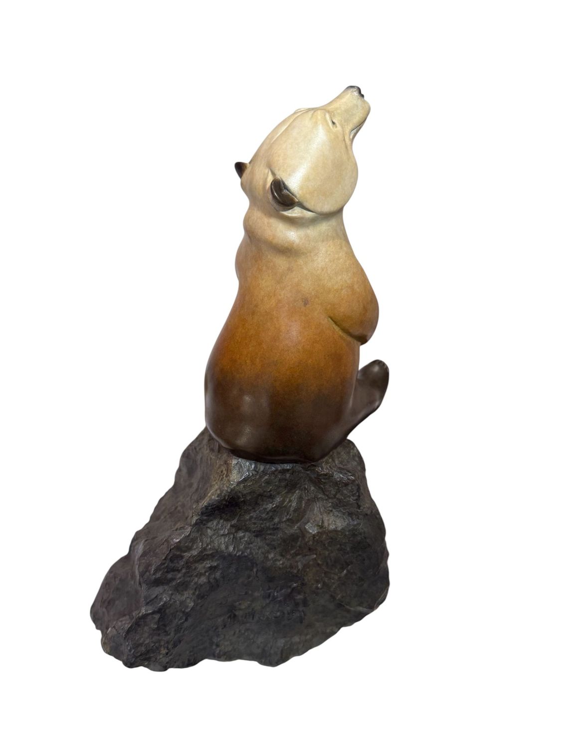 Stone sculpture of a bear on a rock with a white background