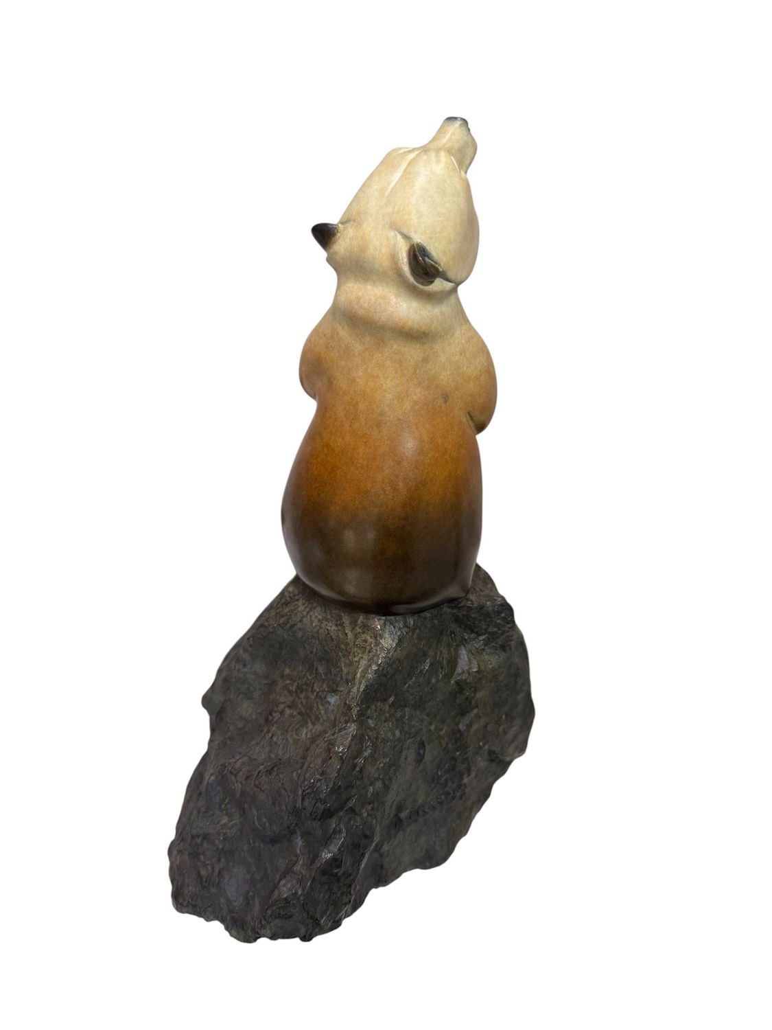 bear figurine on a rock against a white background
