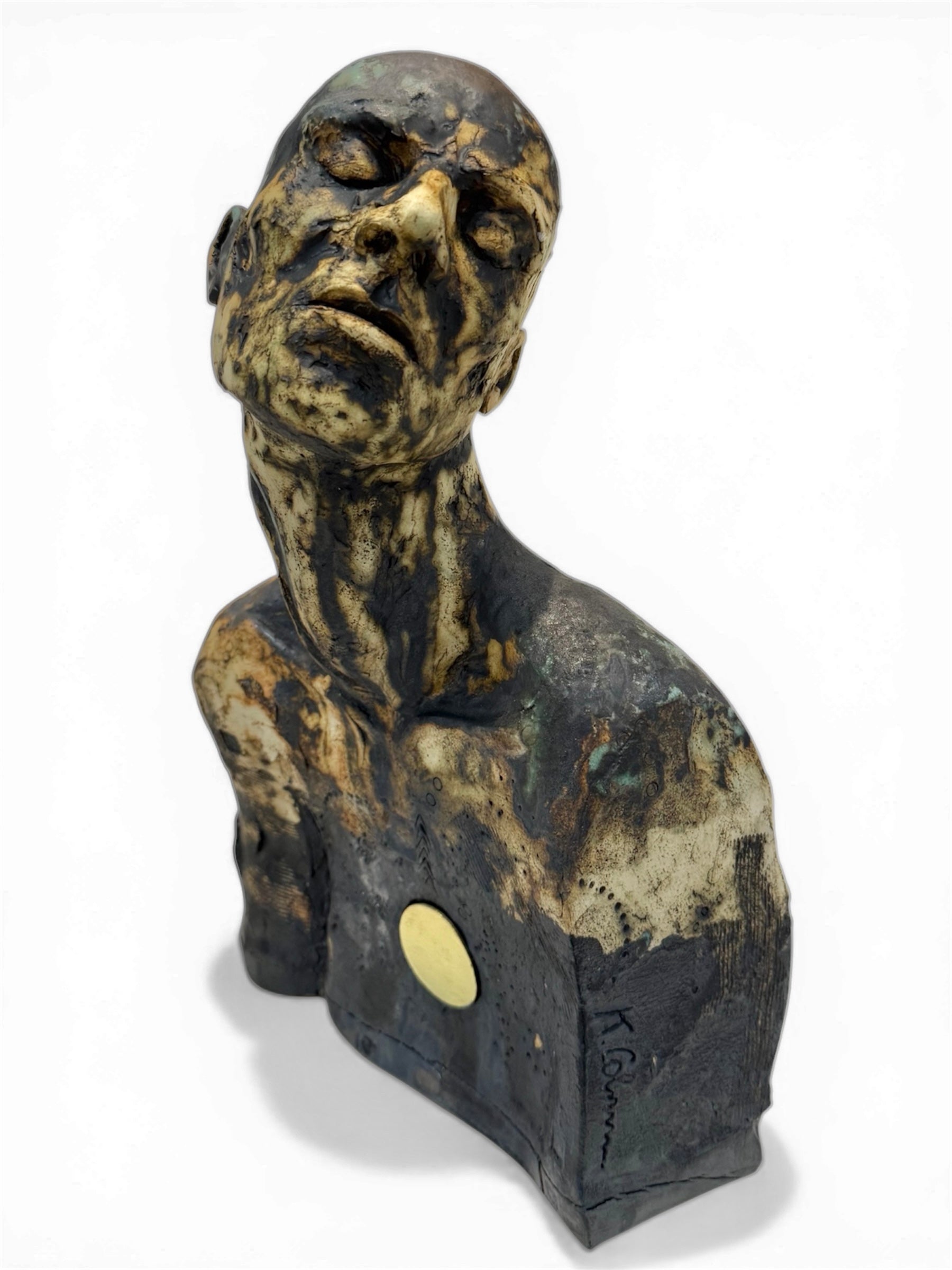 ceramic bust of a thoughtful figure and deep dark shadows all over and a gold badge