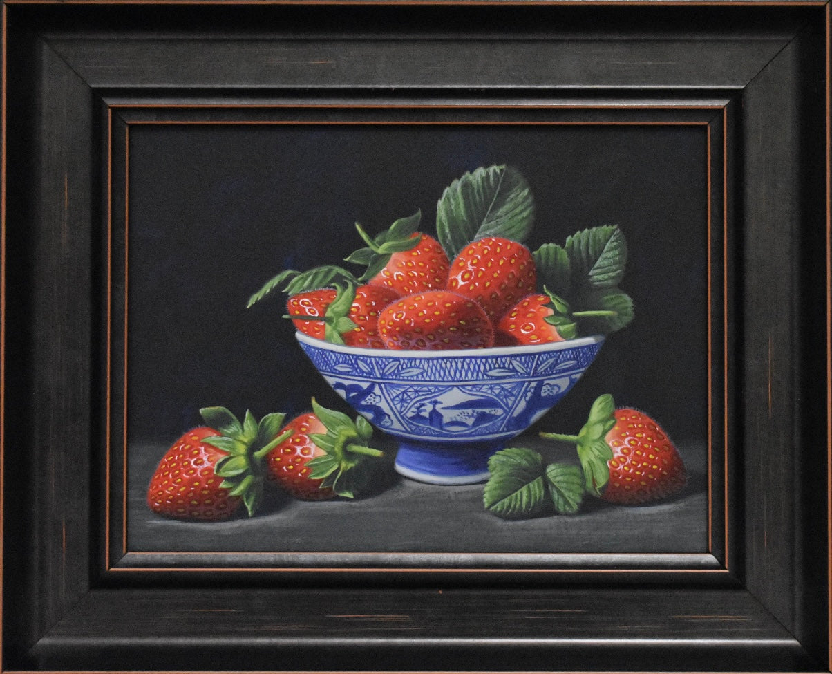 Framed still life painting of strawberries in a blue and white bowl on a dark background