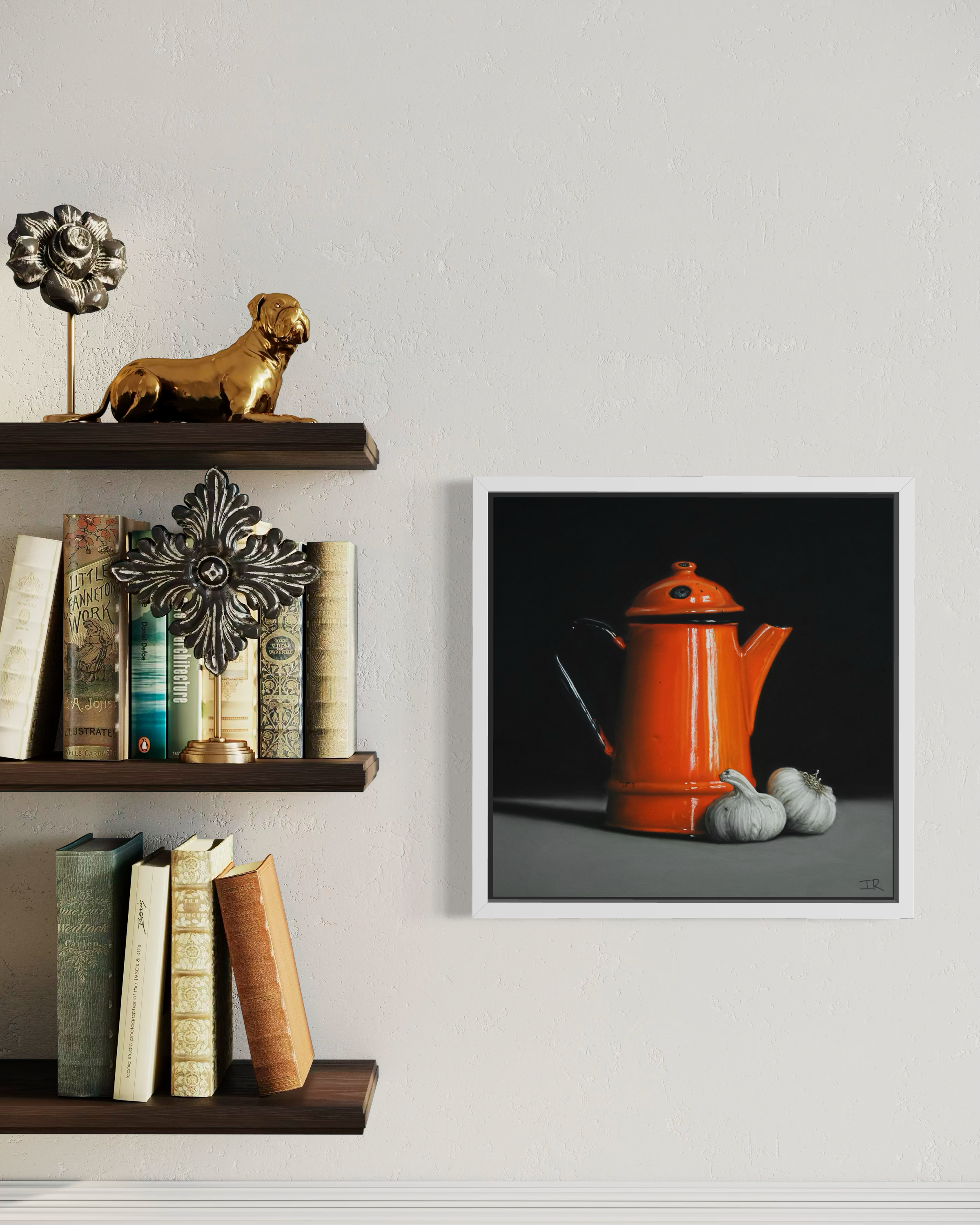 Framed artwork of an orange teapot on a gray background, displayed on a wall next to a shelf with books and decorative items.