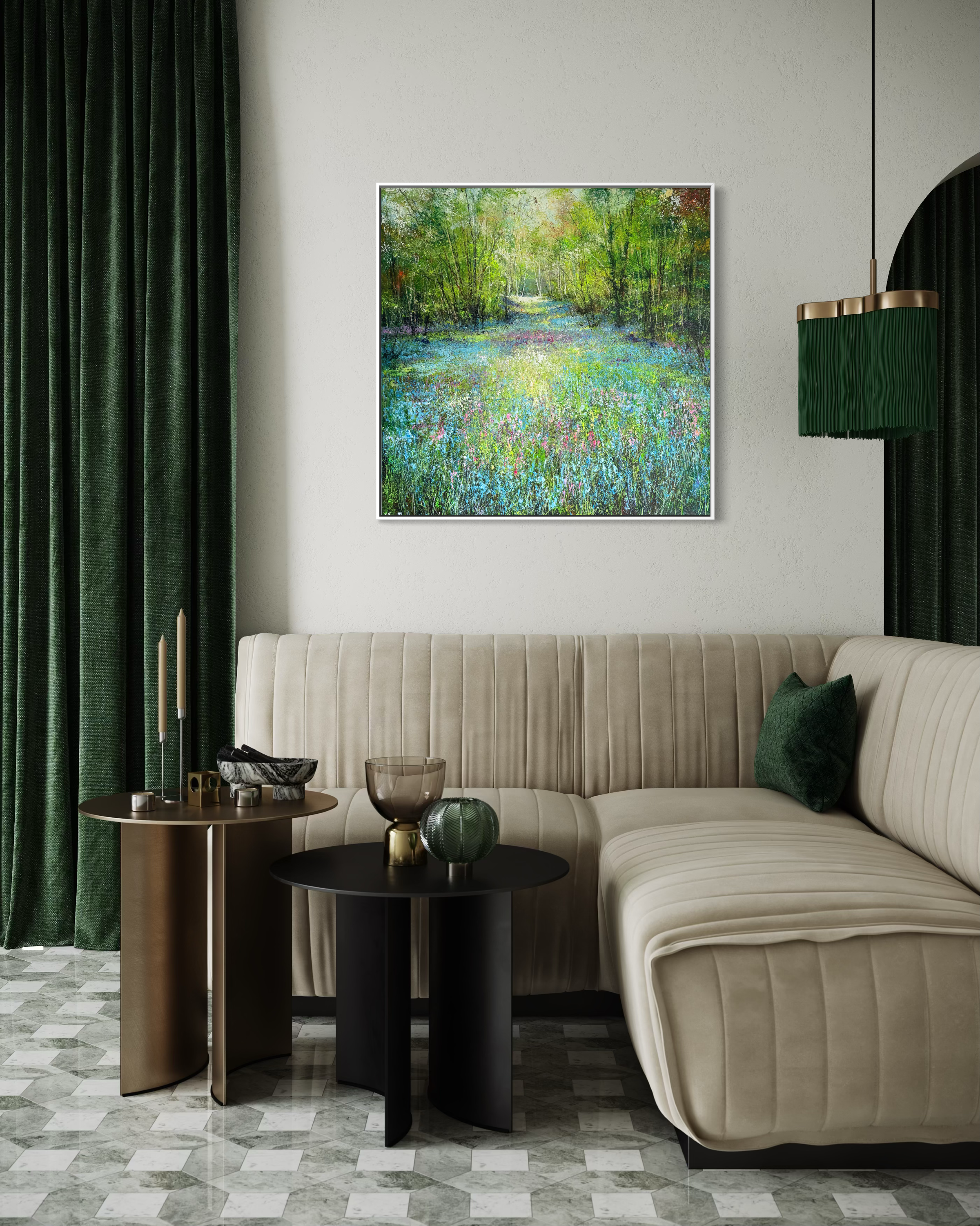 Modern living room with a beige sofa, side tables, and a painting of a nature scene on the wall.