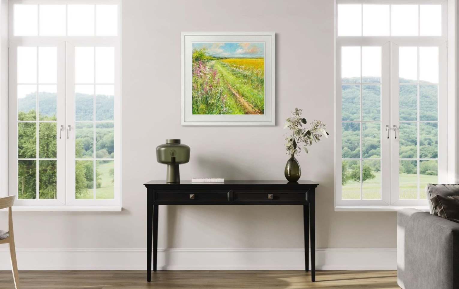 Living room with a black console table, framed colourful landscape artwork, and decorative items.