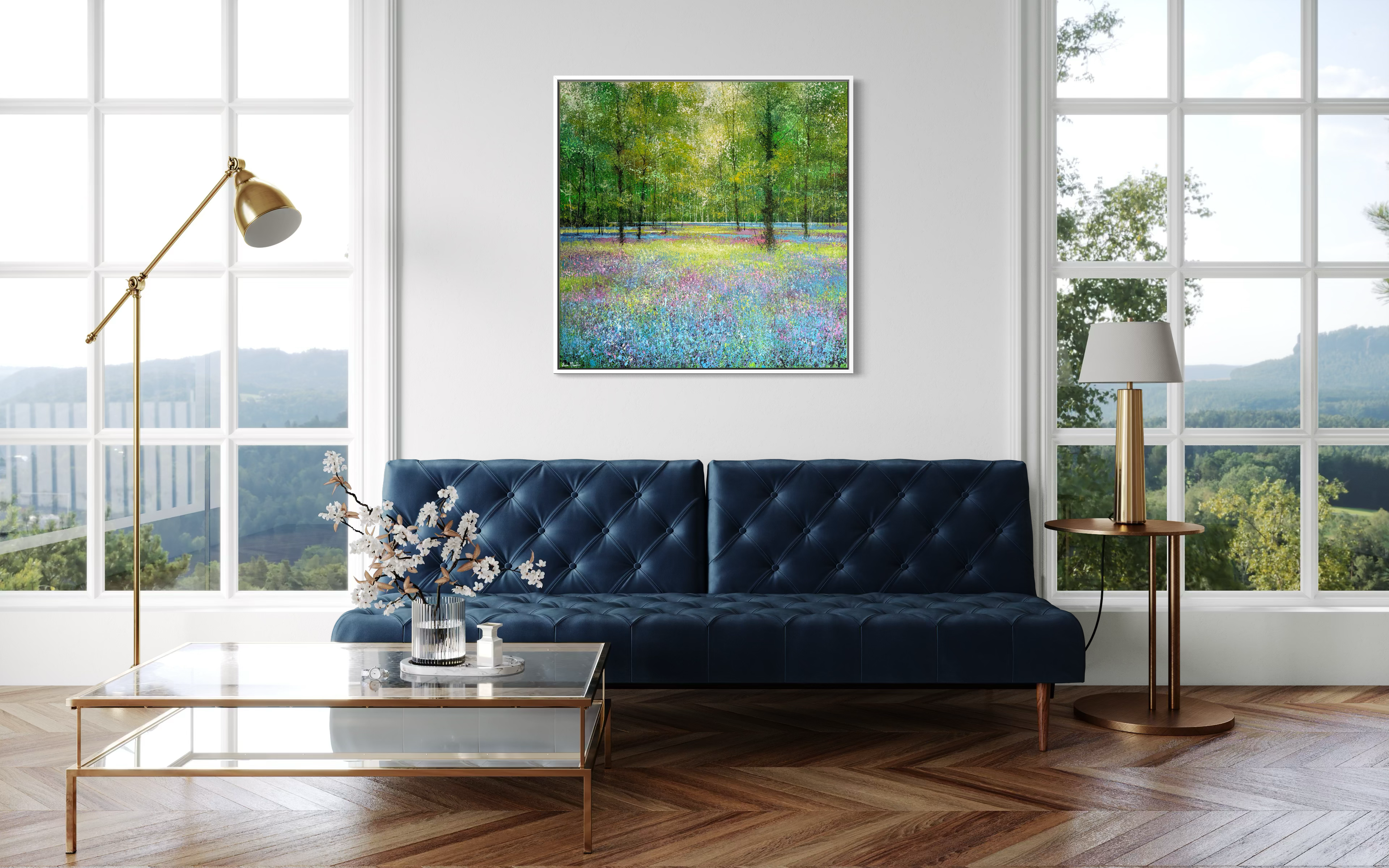 Modern living room with a blue sofa, coffee table, and decorative landscape painting of a bluebell woodland scene on the wall.