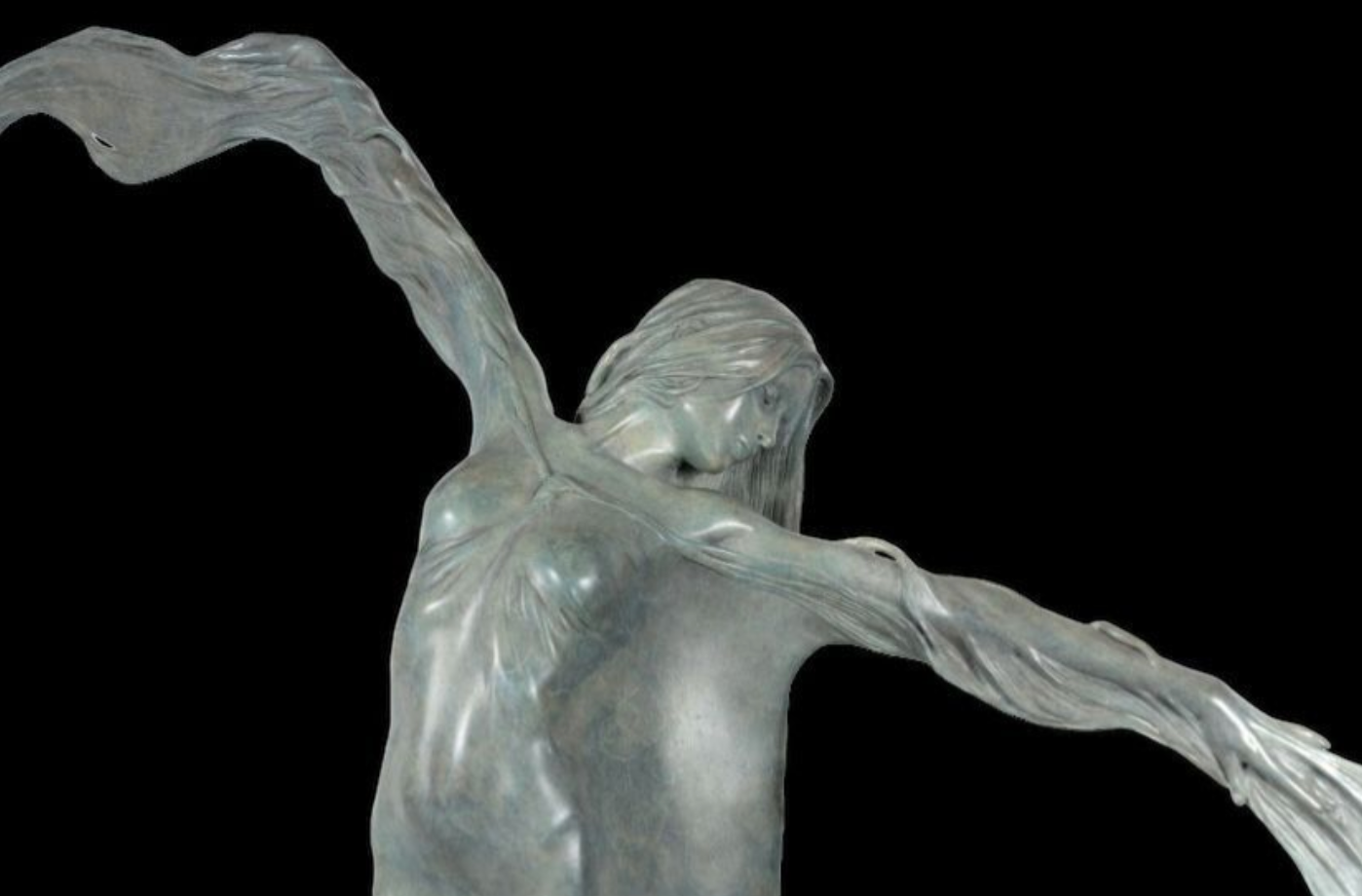 Statue of a winged figure with outstretched arms against a black background