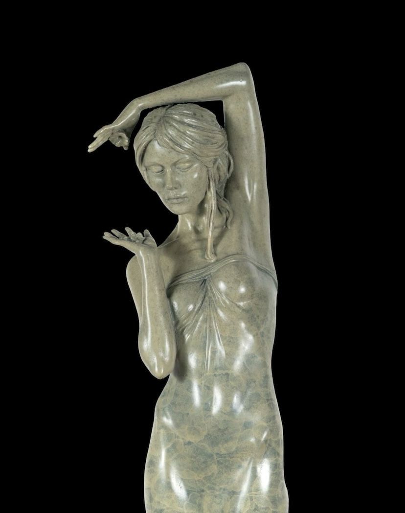 Statue of a woman with outstretched arms on a black background