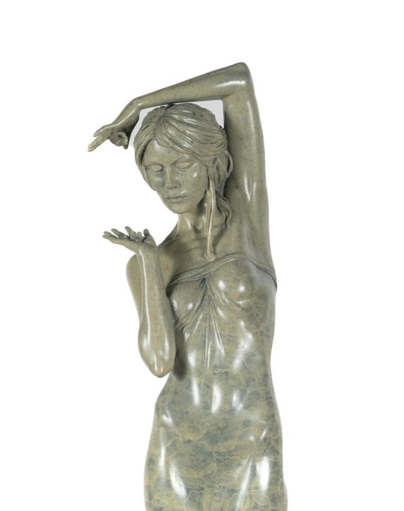 Bronze sculpture of a woman with outstretched arms on a white background