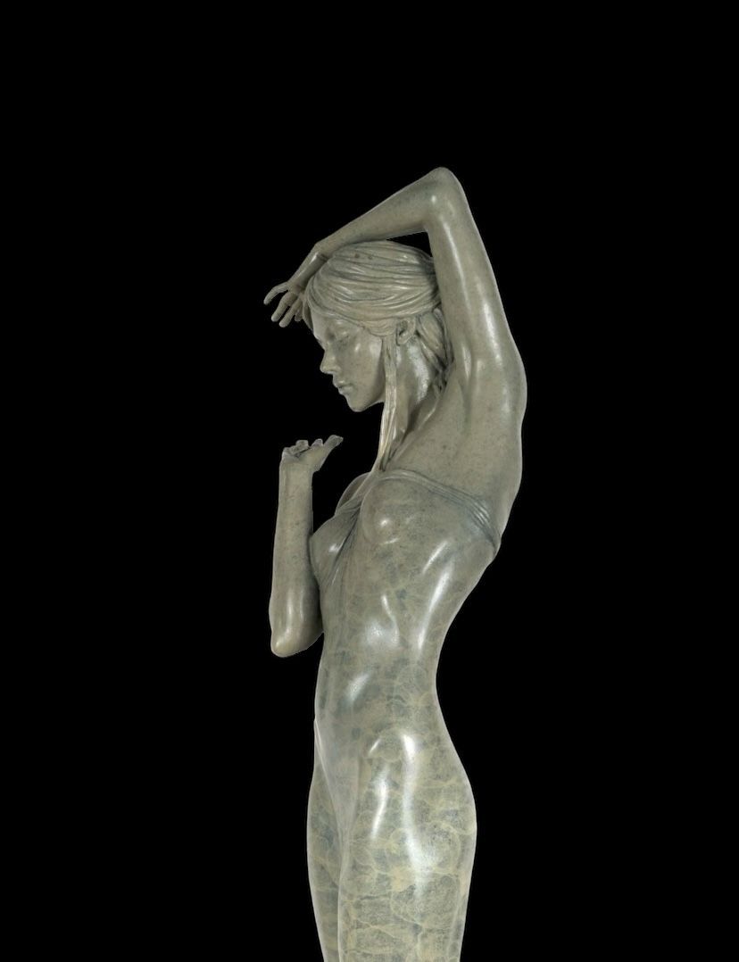 Statue of a woman in a flowing dress against a black background