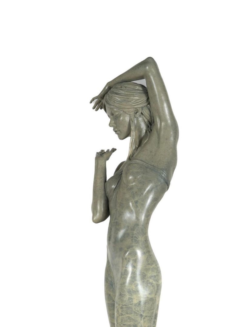 Statue of a woman with her head bowed on a white background