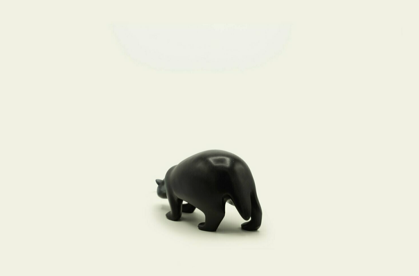 Small black badger figurine on a beige background