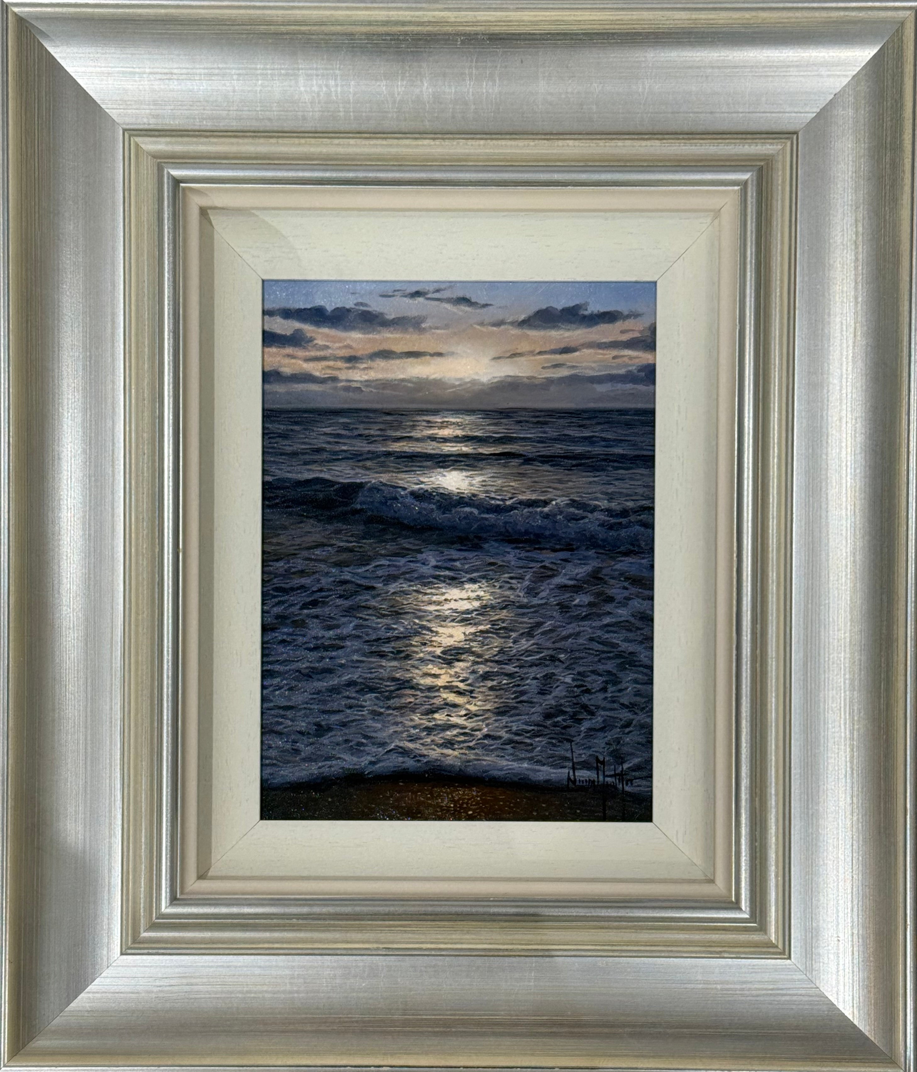 Framed artwork of a coastal scene with waves and sunset.